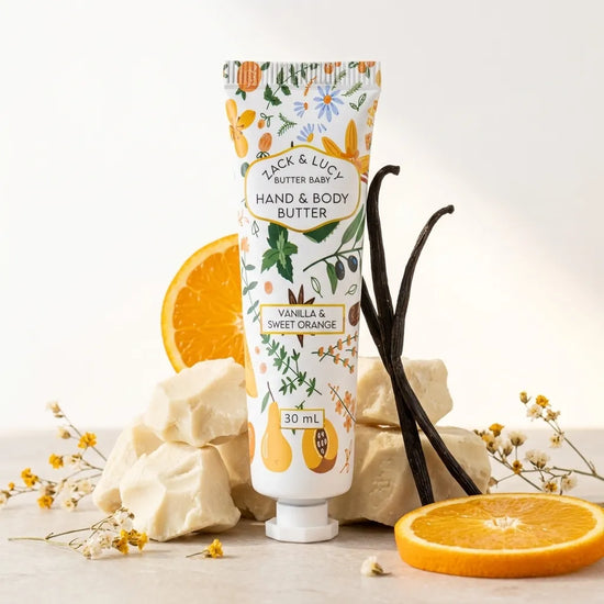 Hand and body butter tube with vanilla and sweet orange flavor, surrounded by orange slices and vanilla beans on a light background.