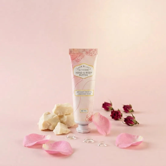 Hand and body butter tube with rose petals and rose buds on a pink background