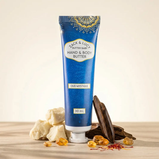 Blue tube of Yack & Lucy Butter Baby Hand & Body Butter with ingredients on a wooden surface